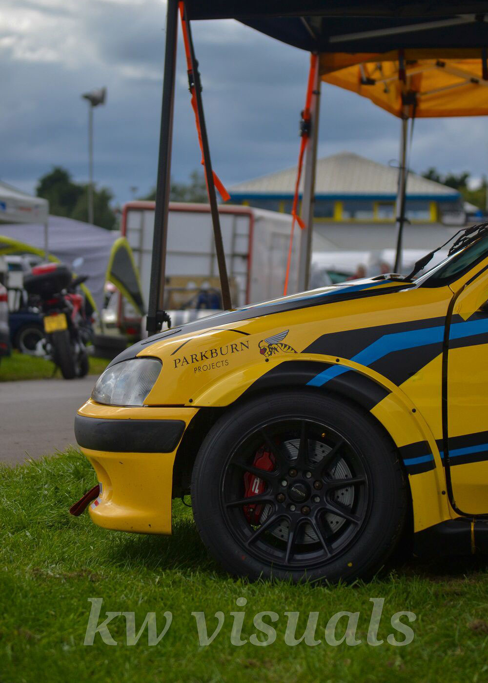 ES Racing Solutions yellow race car with two trophies on the roof